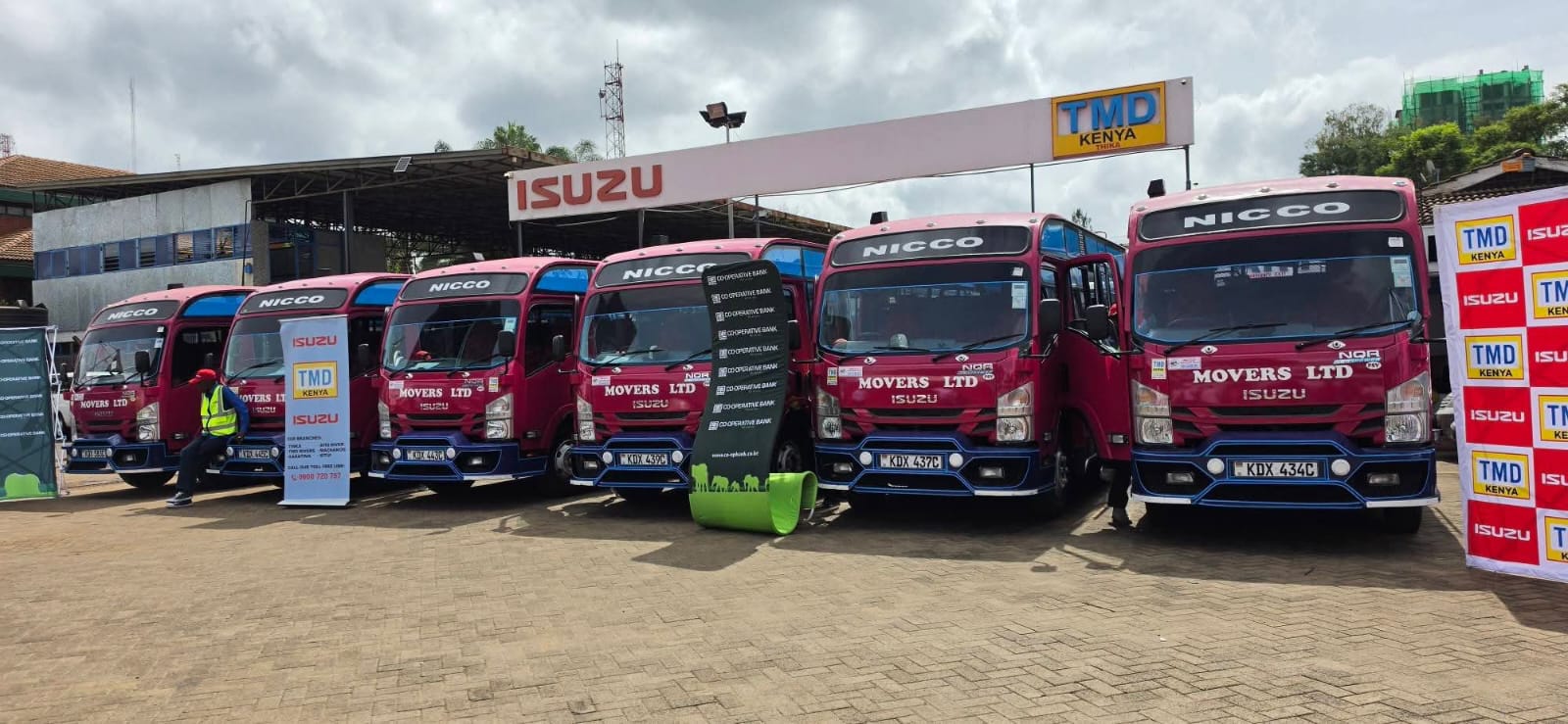 Fleet of Isuzu N-Series trucks at a customer delivery event